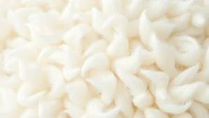 Close-up of soft white baby alpaca wool fiber texture, luxuriously fluffy and delicate, natural lighting highlighting the fineness of the strands